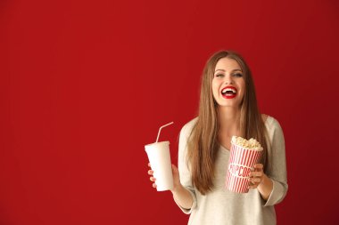 Patlamış mısır ve içecek renk arka plan üzerinde bir güzel genç kadın