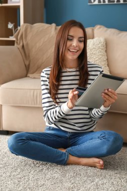 Genç kadın alışveriş online kredi kartı ve tablet Pc vasıl ev ile