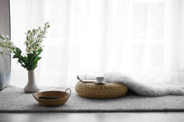 Dinlenmek için rahat bir yer. Pencerenin yanında bir fincan çay ve kitaplar var.