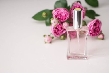 Beyaz zemin üzerine güzel çiçekler ile parfüm şişe