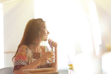 Evde limonata içen genç bir kadın.