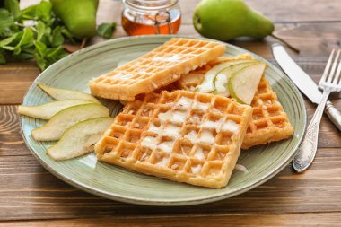 Plaka üzerinde armut dilimleri ile lezzetli waffle