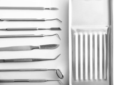 Dişçi araçları ve beyaz arka plan üzerinde metal tepsi
