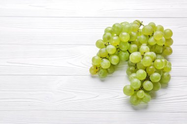 Beyaz ahşap zemin üzerinde olgun tatlı üzüm