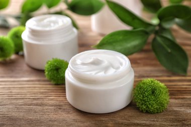 Kavanoz ahşap masa üzerinde vücut kremi ile