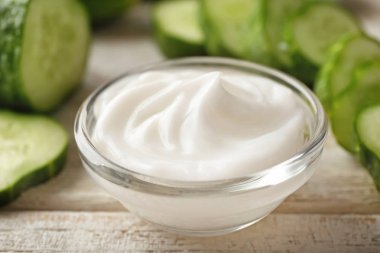 Salatalık beden ahşap masa, closeup krem ile kase