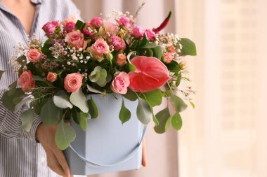 Hediye kutusu güzel çiçekler ile evde tutan kadın