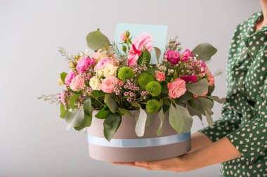 Hediye kutusu ile güzel çiçekler ışık arka plan üzerinde tutan kadın