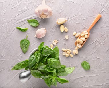 Taze fesleğen, sarımsak ve gri masada fındık ile harç