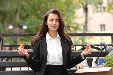 Genç kadın kişisel sayfalar bankta açık havada meditasyon ile ateş