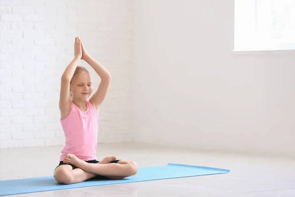 Pomieszczeniu: Little girl Praktykuje jogę — Zdjęcie stockowe