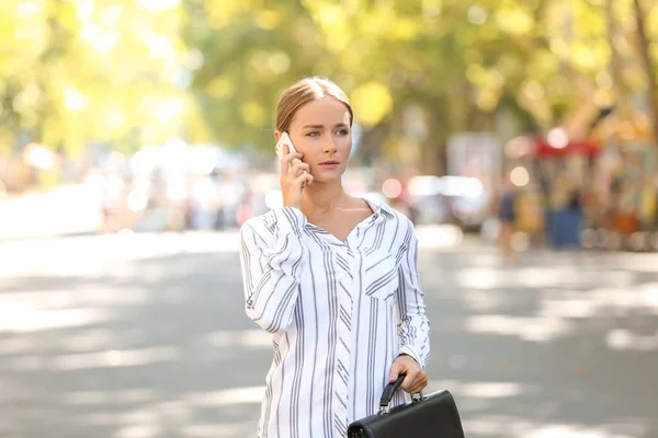 Молода бізнес-леді розмовляє по мобільному телефону на відкритому повітрі — стокове фото