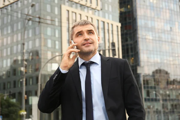 Hombre de negocios guapo hablando en el teléfono móvil al aire libre — Foto de Stock