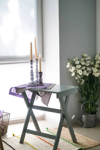 Příjemné místo pro odpočinek s svíčky na stole u okna v kuchyni — Stock fotografie