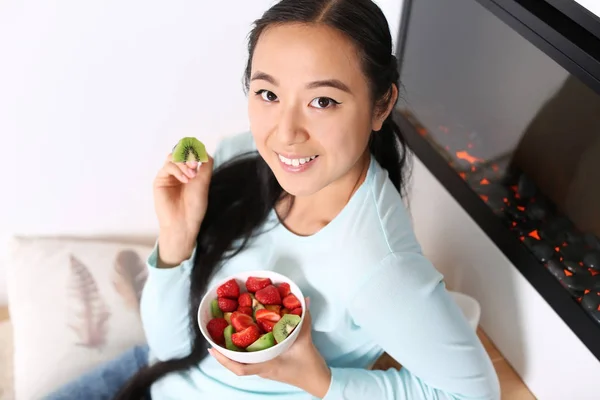 Asyalı kadın evde sağlıklı meyve salatası yemek — Stok fotoğraf