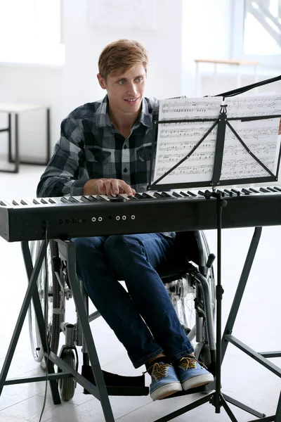 家庭でシンセサイザーを演奏の車椅子の若い音楽家 — ストック写真