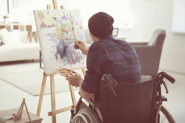 Young artist in wheelchair painting picture at home — Stock Photo, Image