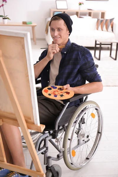 Young artist in wheelchair painting picture at home — Stock Photo, Image