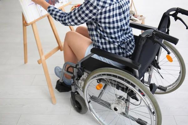 Young female artist in wheelchair painting picture at home — Stock Photo, Image