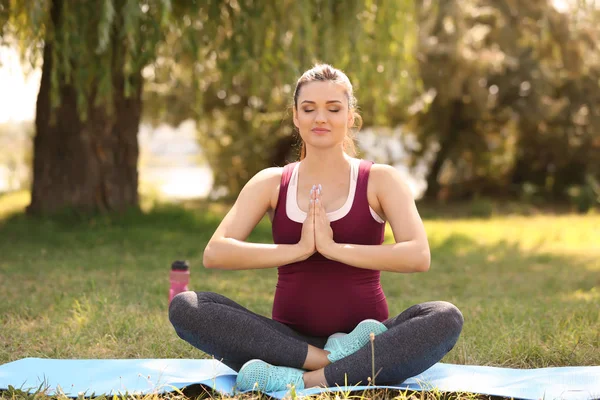 Young pregnant woman practicing yoga outdoors — Stock Photo, Image