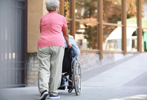 Senior man in wheelchair and his wife on ramp outdoors — Stock Photo, Image