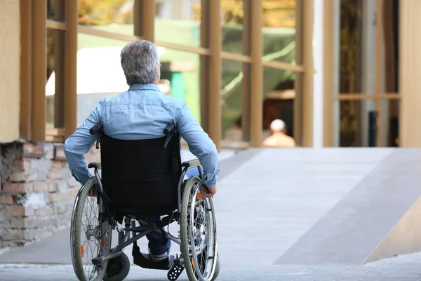Старший в инвалидной коляске возле пандуса на открытом воздухе — стоковое фото