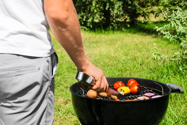 Man cooking tasty vegetables on barbecue grill outdoors — Stock Photo, Image