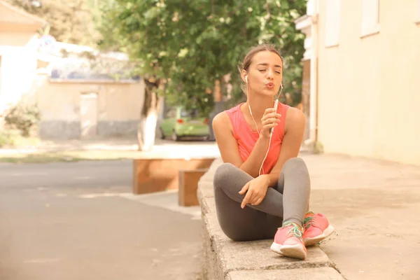 Mujer joven deportiva escuchando música al aire libre —  Fotos de Stock