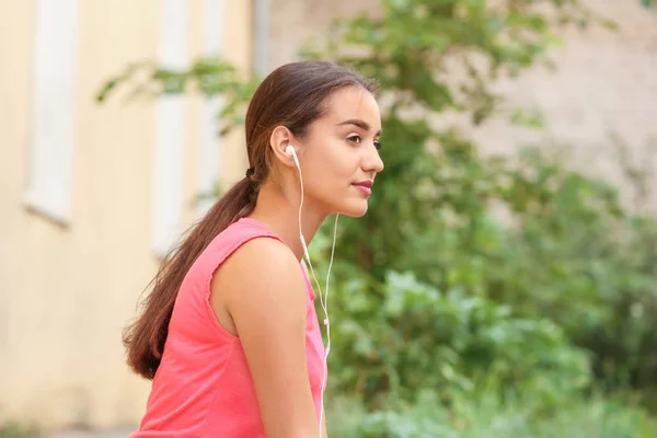 Beautiful young woman listening to music outdoors — Stock Photo, Image