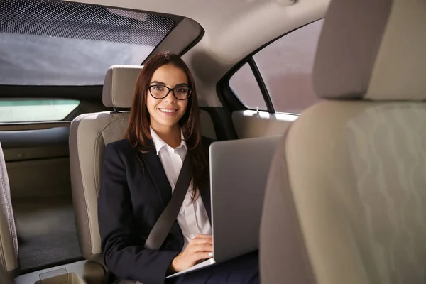 Jovem empresária com laptop no carro — Fotografia de Stock