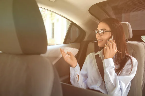 Mladá podnikatelka mluvit na mobilním telefonu v autě — Stock fotografie