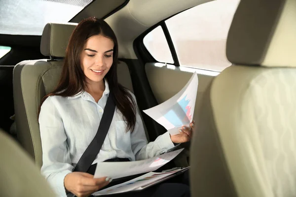 Jovem empresária que trabalha com documentos em carro — Fotografia de Stock