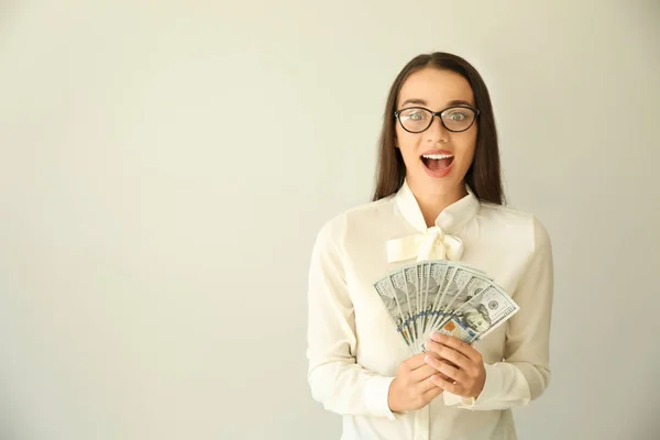 Happy businesswoman with money on light background — Stock Photo, Image