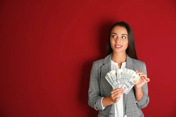Joven mujer de negocios con dinero en el fondo de color — Foto de Stock