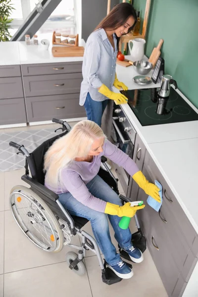 Zralá žena vozíku čištění kuchyně spolu s dcerou — Stock fotografie