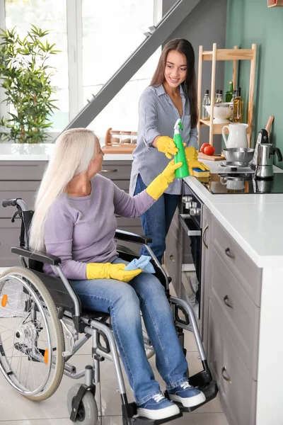 Starsza kobieta na wózku inwalidzkim, czyszczenie kuchni wraz z Córka — Zdjęcie stockowe