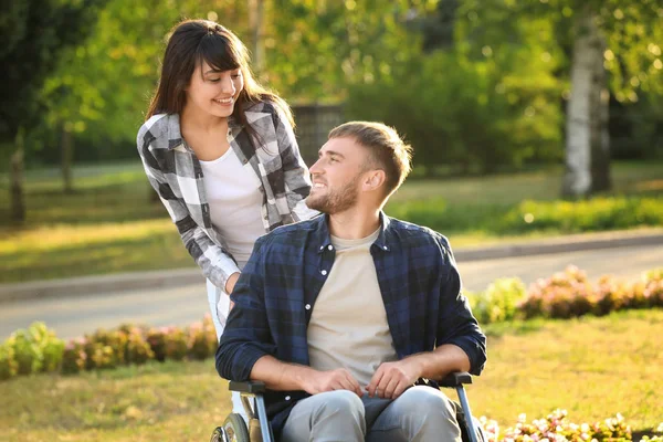 Молодий чоловік в інвалідному візку і його дружина на відкритому повітрі — стокове фото