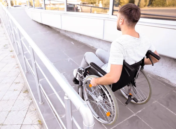 Jovem em cadeira de rodas na rampa ao ar livre — Fotografia de Stock