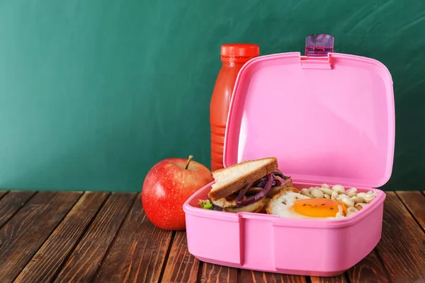 Lunch box with appetizing food on wooden table — Stock Photo, Image