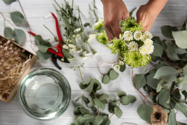 Florista feminina fazendo belo buquê com flores de crisântemo — Fotografia de Stock