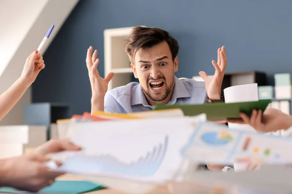 Gestresster Arbeitnehmer sitzt im Büro am Tisch — Stockfoto