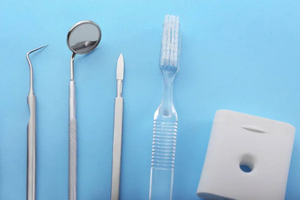 Uppsättning av tandläkarens verktyg, tandborste och tandtråd på färgbakgrund — Stockfoto