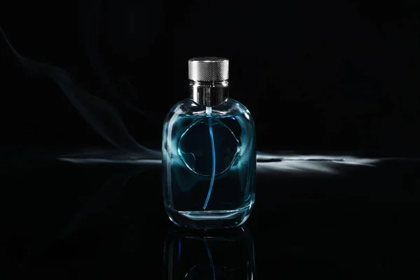 Fles parfum met rook op donkere achtergrond — Stockfoto
