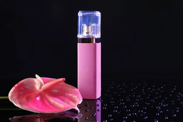 Fles parfum met tropische bloem op donkere achtergrond — Stockfoto