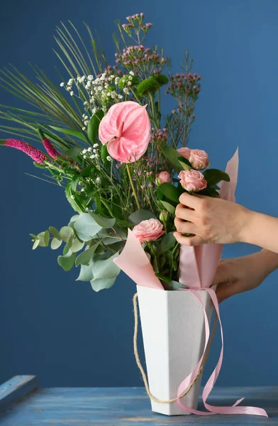 컬러 배경 테이블에서 아름 다운 꽃의 꽃다발을 준비 하는 여성 꽃집 — 스톡 사진