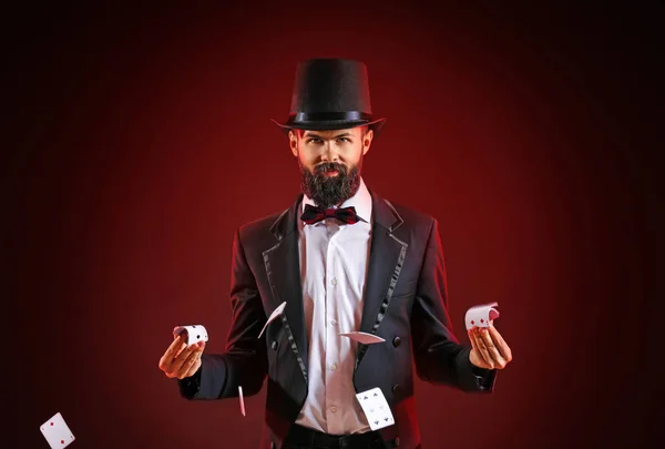 Mágico mostrando truques com cartões no fundo escuro — Fotografia de Stock