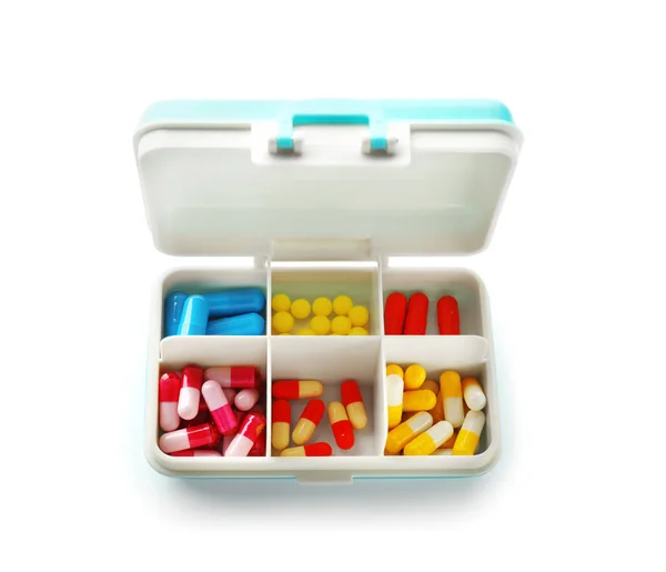 Conteneur en plastique avec différentes pilules sur fond blanc — Photo