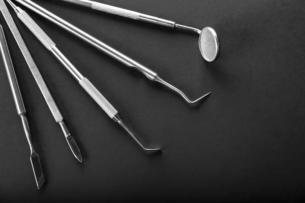 Werkzeuge des Zahnarztes auf schwarzem Hintergrund — Stockfoto