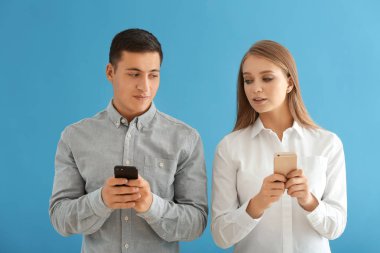 Cep telefonlarıyla renk arka plan üzerinde genç çift