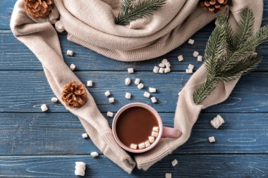 Sıcak çikolata şekerleme ve ahşap masa üzerinde sıcak kazak